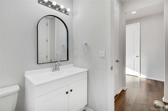 bathroom with vanity, hardwood / wood-style flooring, and toilet