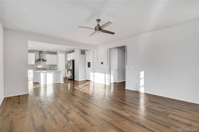 unfurnished living room featuring ceiling fan and dark hardwood / wood-style floors