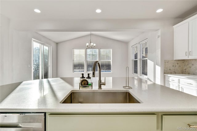 kitchen with decorative backsplash, sink, pendant lighting, an inviting chandelier, and lofted ceiling