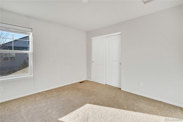 unfurnished bedroom with carpet flooring and a closet