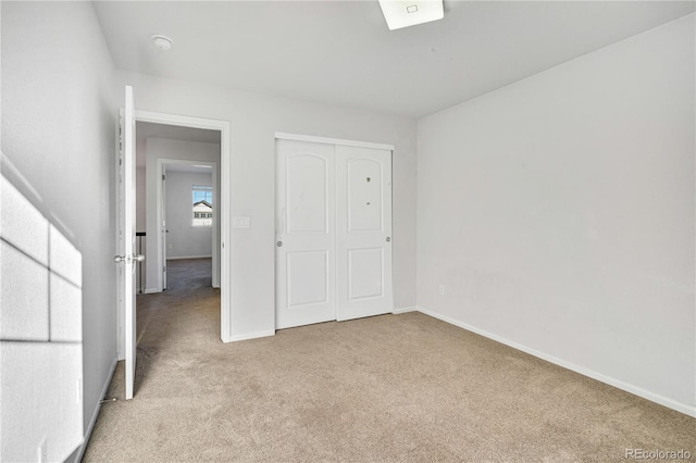 unfurnished bedroom with a closet and light colored carpet