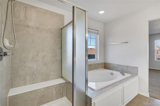 bathroom featuring tile patterned floors and shower with separate bathtub