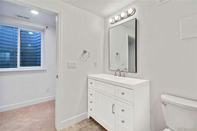 bathroom featuring tile patterned flooring, vanity, toilet, and a textured ceiling