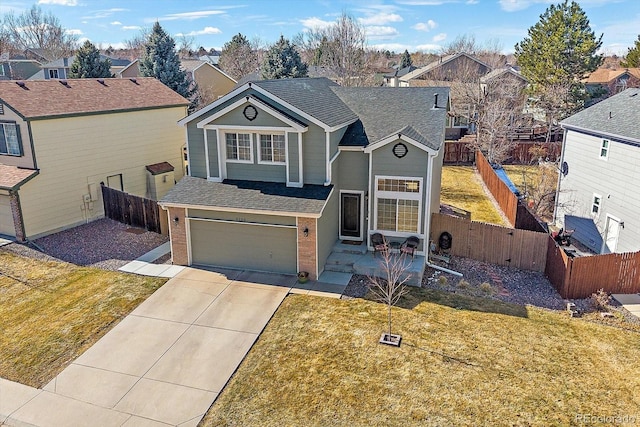 traditional-style home with an attached garage, a residential view, concrete driveway, and brick siding