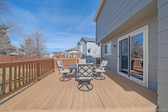 wooden terrace with outdoor dining space and fence