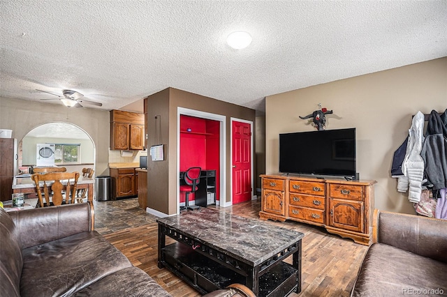 547 S 3rd Ave, Brighton, CO 80601 - living area with a textured ceiling, ceiling fan, wood finished floors, baseboards, and arched walkways