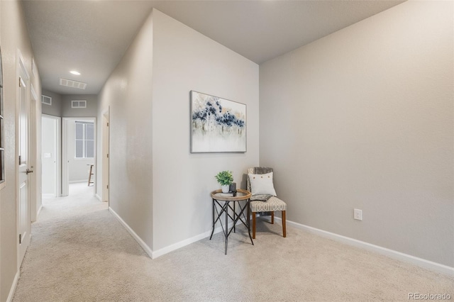 hallway featuring light colored carpet