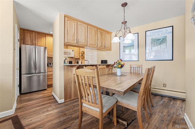 dining area with dark wood-type flooring, a chandelier, and baseboard heating