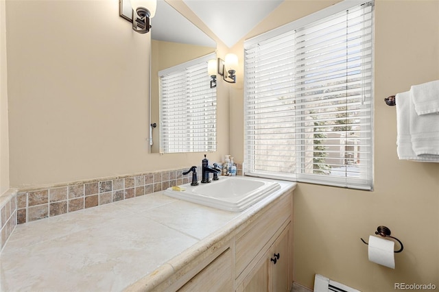 bathroom with baseboard heating, vanity, and lofted ceiling