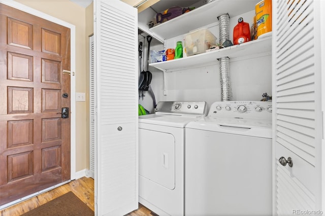 laundry area featuring washing machine and dryer and light hardwood / wood-style flooring