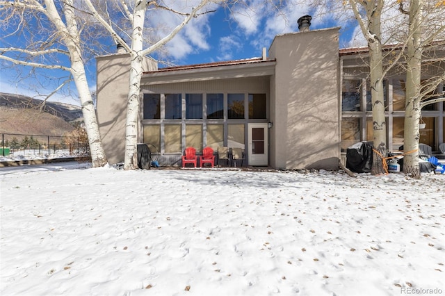 view of snow covered rear of property