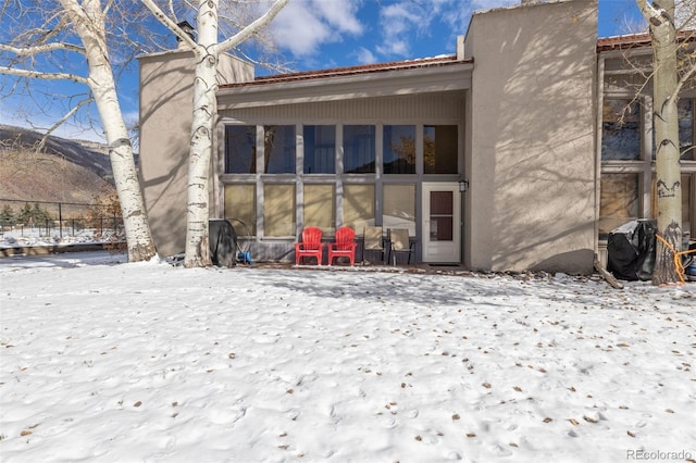 view of snow covered rear of property