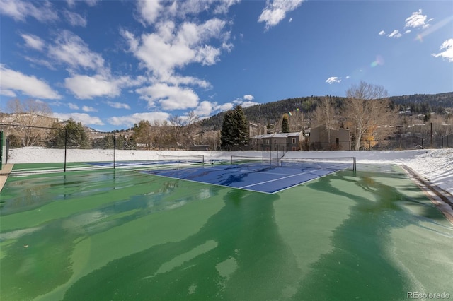 view of tennis court featuring a mountain view