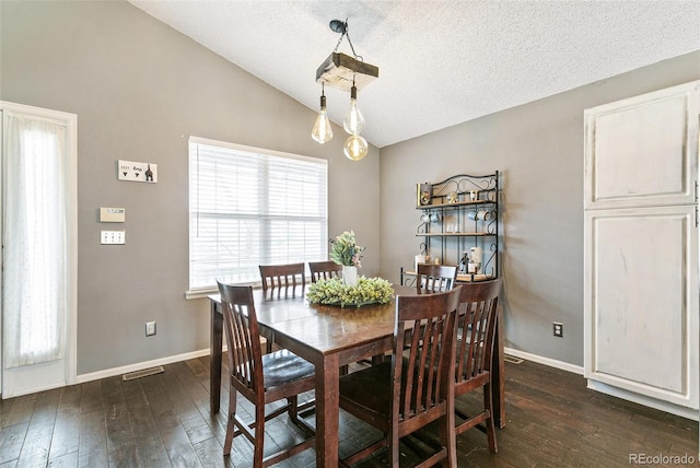 dining room with dark wood finished floors, vaulted ceiling, baseboards, and visible vents