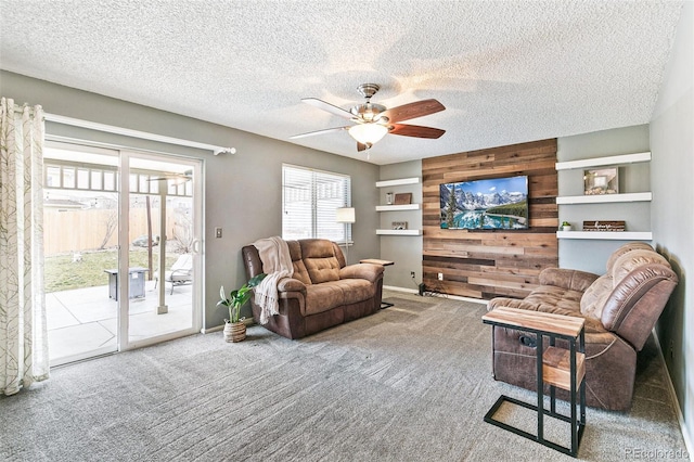 living room featuring wooden walls, carpet floors, and a textured ceiling