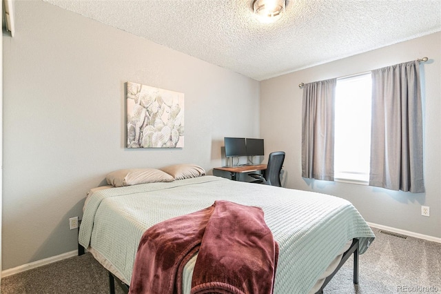 carpeted bedroom featuring visible vents, baseboards, and a textured ceiling