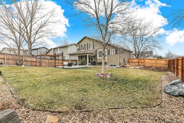 back of property with a yard, a patio, and a fenced backyard