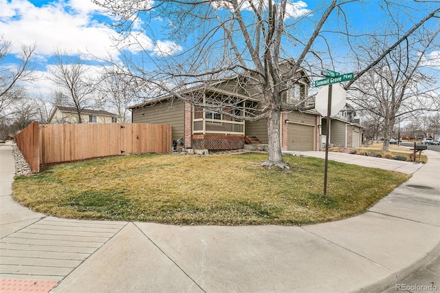 view of front of home with fence, concrete driveway, a front lawn, a garage, and brick siding