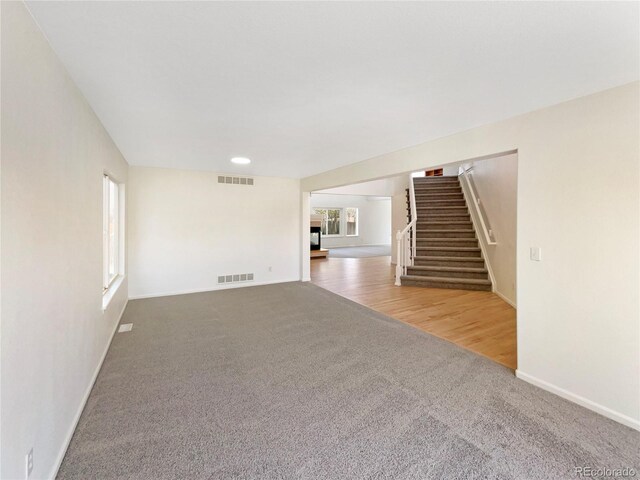 18951 E 43rd Ave, Denver, CO 80249 - unfurnished living room featuring visible vents, baseboards, carpet flooring, and stairs