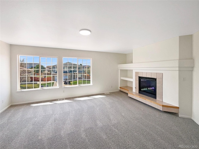 18951 E 43rd Ave, Denver, CO 80249 - unfurnished living room with carpet floors, a tile fireplace, and baseboards