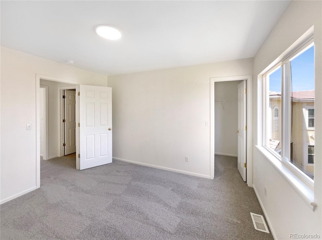 18951 E 43rd Ave, Denver, CO 80249 - unfurnished bedroom featuring a walk in closet, baseboards, visible vents, and carpet