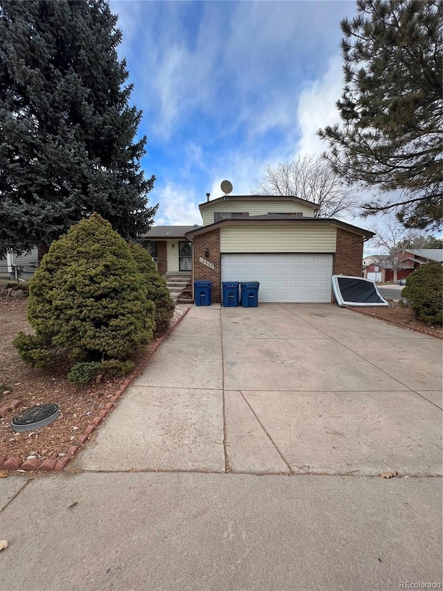 view of front of house with an attached garage, concrete driveway, and brick siding