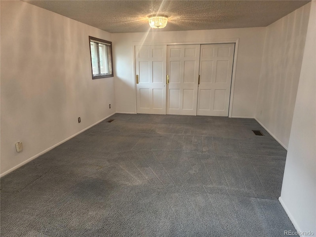 6961 E Arkansas Ave, Denver, CO 80224 - unfurnished bedroom featuring dark carpet, a textured ceiling, and a closet
