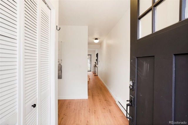 hallway featuring a baseboard radiator and light hardwood / wood-style floors