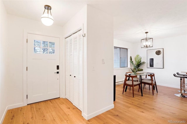 foyer entrance with an inviting chandelier, light hardwood / wood-style floors, and a healthy amount of sunlight