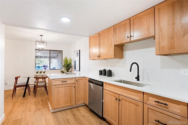 kitchen featuring sink, decorative light fixtures, dishwasher, kitchen peninsula, and a notable chandelier