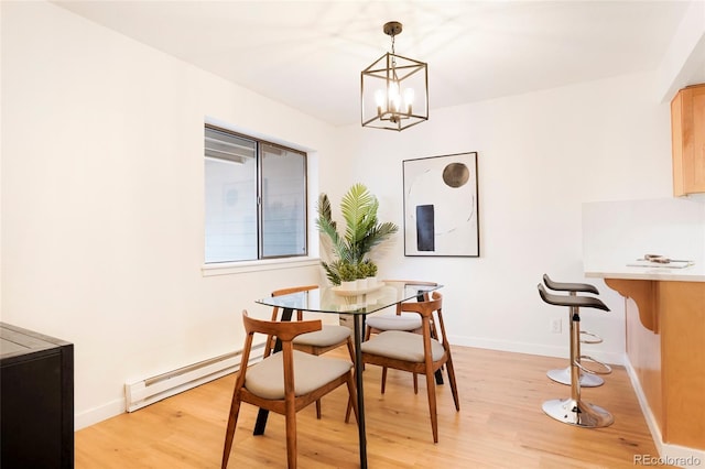 dining space with baseboard heating, light wood-type flooring, and a chandelier