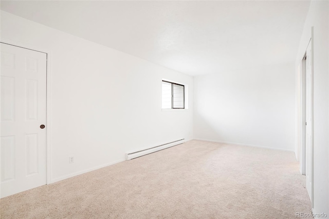 spare room featuring light colored carpet and a baseboard radiator