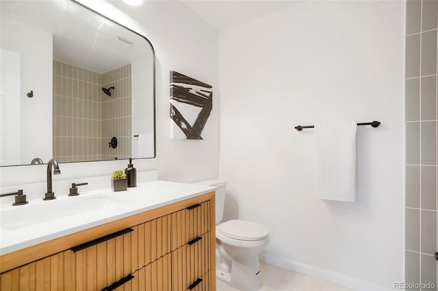 bathroom with tiled shower, tile patterned floors, vanity, and toilet