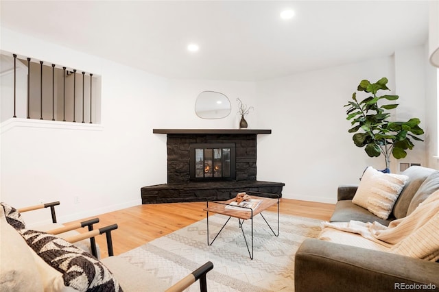 living room featuring light hardwood / wood-style floors and a stone fireplace