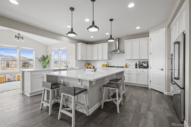 9021 Swan River St, Littleton, CO 80125 - kitchen featuring wall chimney exhaust hood, white cabinetry, dark wood-style flooring, recessed lighting, and lofted ceiling
