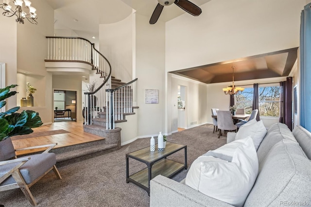 living room with visible vents, a raised ceiling, stairway, carpet flooring, and baseboards