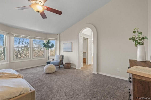 carpeted bedroom with lofted ceiling, baseboards, arched walkways, and ceiling fan