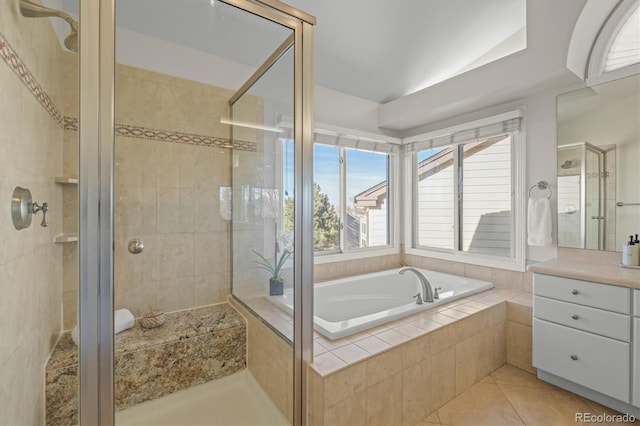 bathroom featuring vanity, a stall shower, vaulted ceiling, tile patterned floors, and a bath