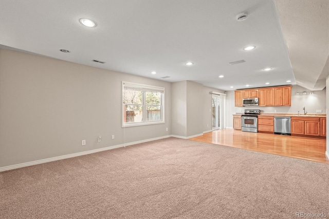 kitchen featuring visible vents, recessed lighting, appliances with stainless steel finishes, light carpet, and open floor plan