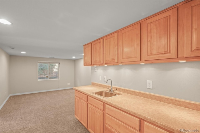 kitchen with light carpet, a sink, recessed lighting, light countertops, and baseboards