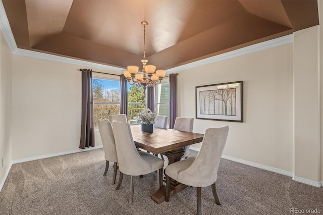 dining area featuring crown molding, carpet floors, a chandelier, a raised ceiling, and baseboards