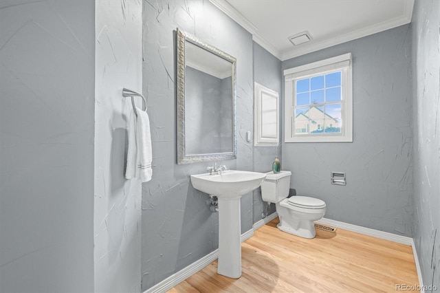 half bath featuring baseboards, ornamental molding, toilet, and wood finished floors