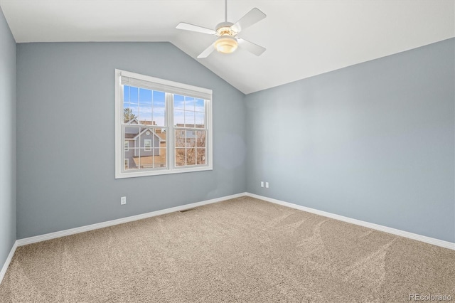 carpeted empty room with visible vents, ceiling fan, baseboards, and vaulted ceiling