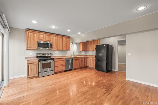 kitchen featuring appliances with stainless steel finishes, light wood finished floors, light countertops, and recessed lighting