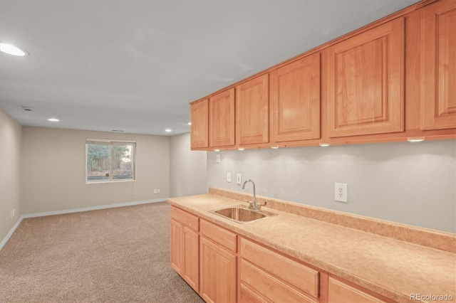 kitchen with light colored carpet, recessed lighting, light countertops, a sink, and baseboards