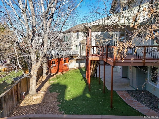 view of yard featuring a wooden deck, fence, a patio area, and stairs