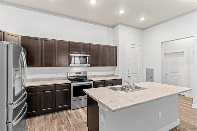 14301 E Tennessee Ave Unit 109, Aurora, CO 80012 - kitchen with appliances with stainless steel finishes, a sink, light wood-style flooring, dark brown cabinets, and a center island with sink