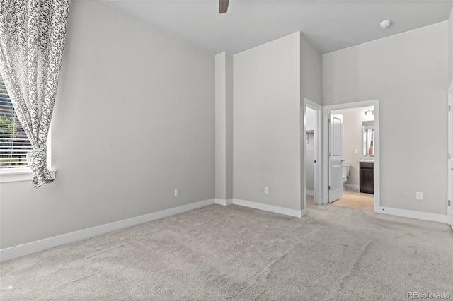 14301 E Tennessee Ave Unit 109, Aurora, CO 80012 - unfurnished bedroom with light colored carpet, baseboards, ensuite bathroom, and ceiling fan