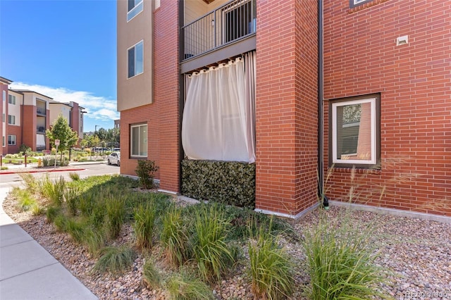 14301 E Tennessee Ave Unit 109, Aurora, CO 80012 - view of side of home featuring a balcony and brick siding