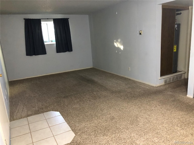 carpeted spare room featuring water heater